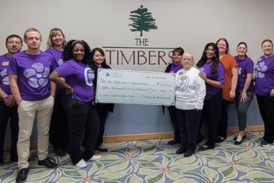 Timbers of Shorewood staff holding a check to donate to Alzheimer's Association